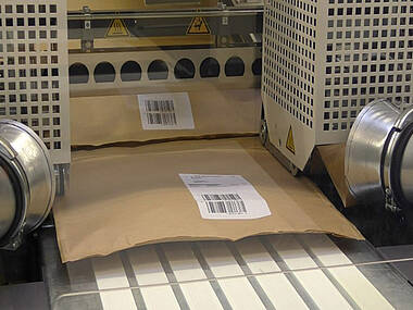 Outfeed with packed products and paper strip extraction